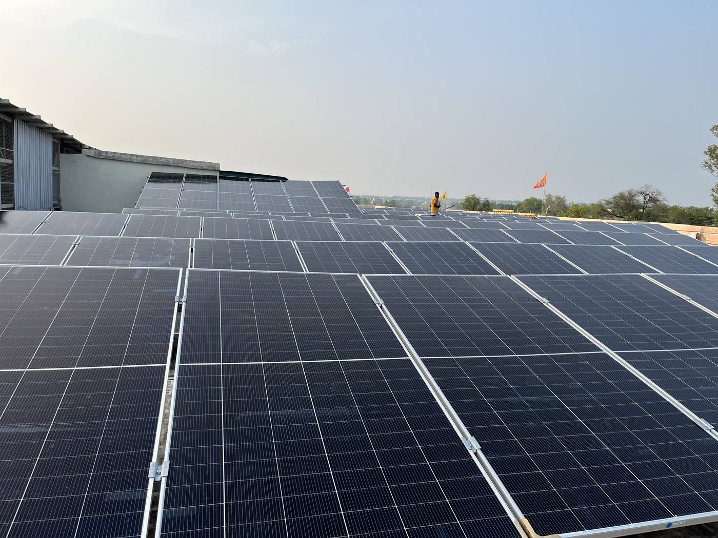 Rows of solar panels on a flat roof at dusk